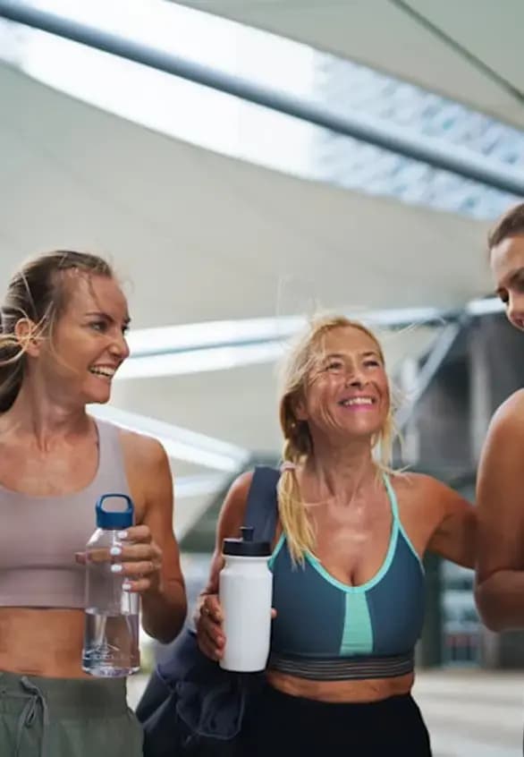 Three women walking together outdoors after a workout